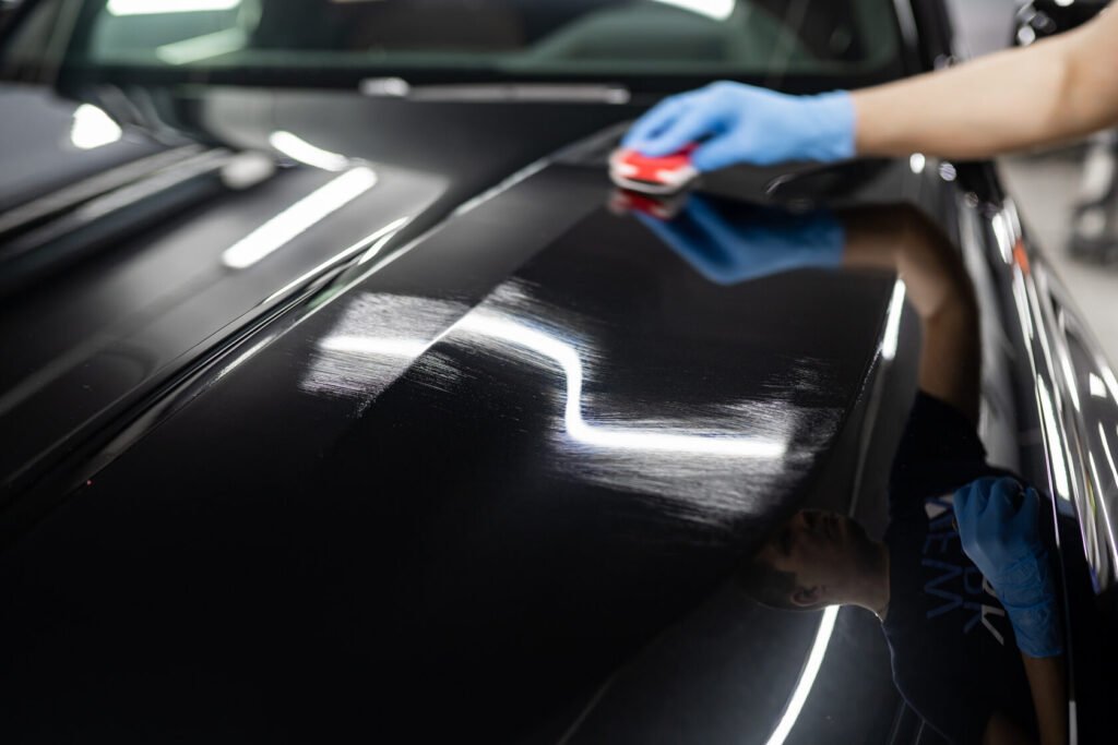 Technician applying ceramic coating to car paint
